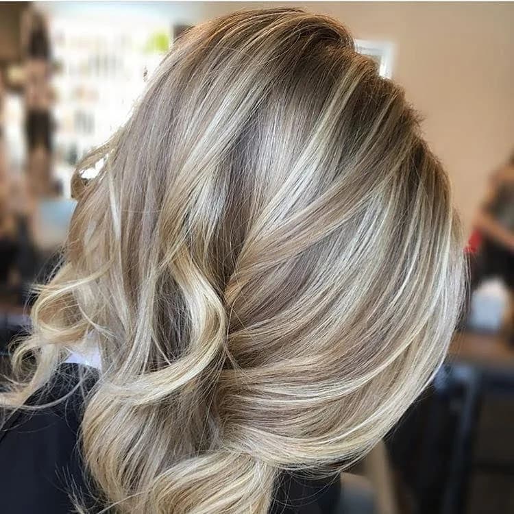 Loiro com mechas em cabelo ondulado Loiro com mechas em cabelo ondulado
